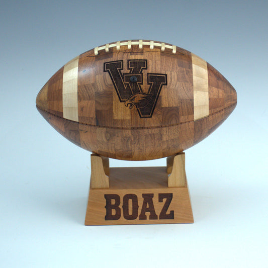 Personalized handcrafted wooden football gift with engraved school logo and base.