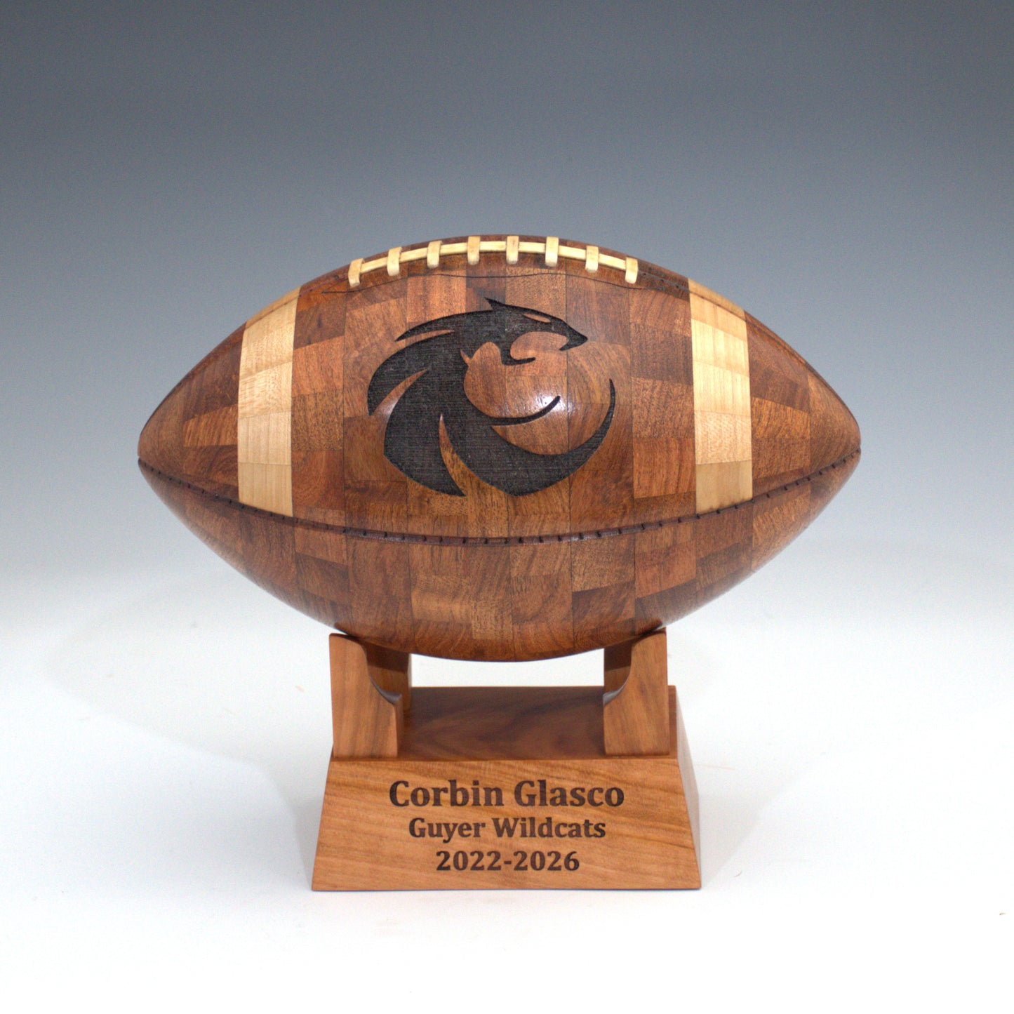 Wooden football-shaped trophy with a logo